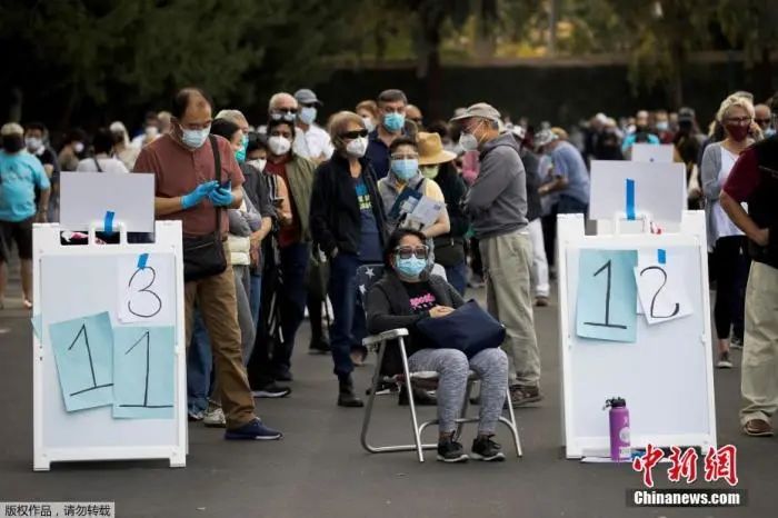 当地时间2021年1月13日,美国加利福尼亚州安纳海姆,美国加利福尼亚州橙县政府宣布,政府在当地迪士尼乐园度假区内安置了大型临时新冠疫苗接种点,位于园区东南部。据路透社11日报道,迪士尼接种点建成后,将成为橙县首个大规模疫苗接种点。加州迪士尼乐园自2020年3月份以来一直处于关闭状态,园方医疗主管帕梅拉·海默尔称,“能为抗疫工作做出贡献,我们非常荣幸”。图为人们在加州迪士尼乐园度假区接种疫苗的地点排长队等候。 图片